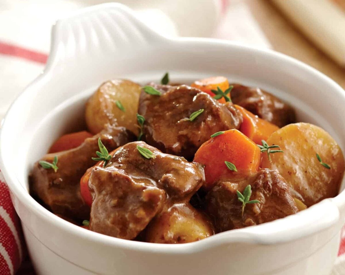 Instant Pot beef stew in a bowl showing chunks of beef, potatoes, and carrots.r