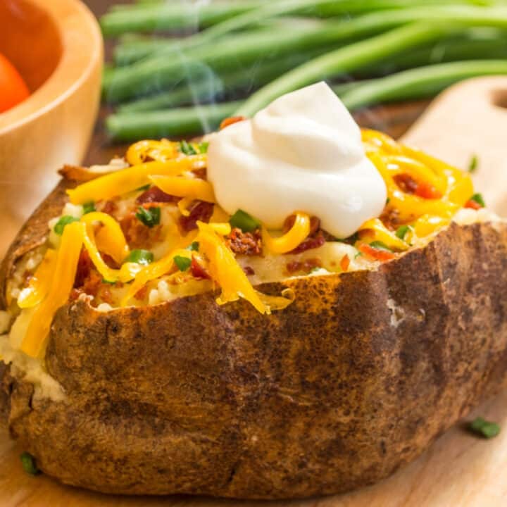closeup of air fryer baked potato loaded with toppings