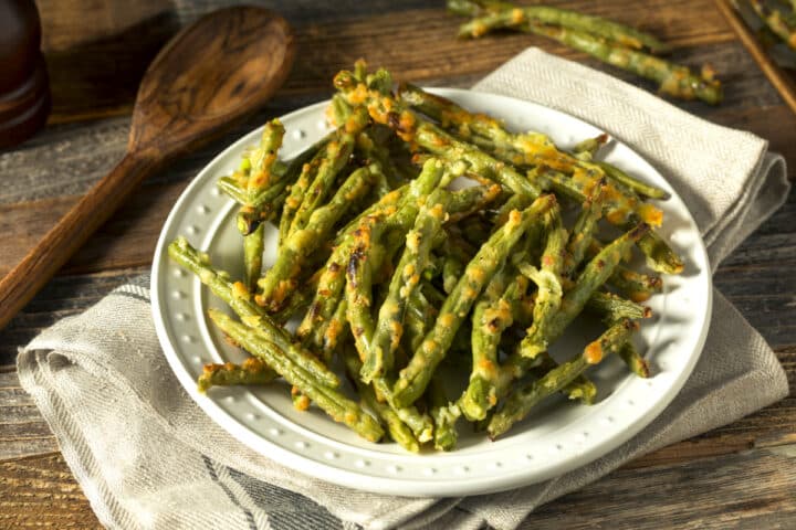 air fryer crispy green beans with seasonings on a white plate