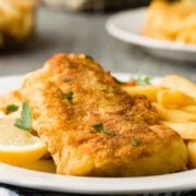closeup of panko crusted baked cod with a lemon wedge and fries