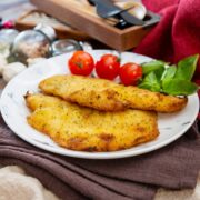 2 pieces of baked flounder with crispy coating on a white plate.