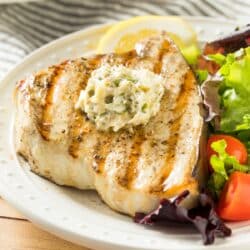 closeup of baked swordfish with garlic butter
