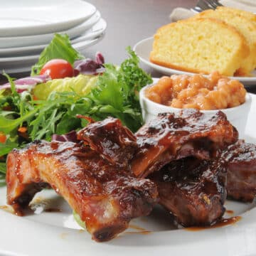 Ribs in the Oven With Side Dishes and white plates in the background