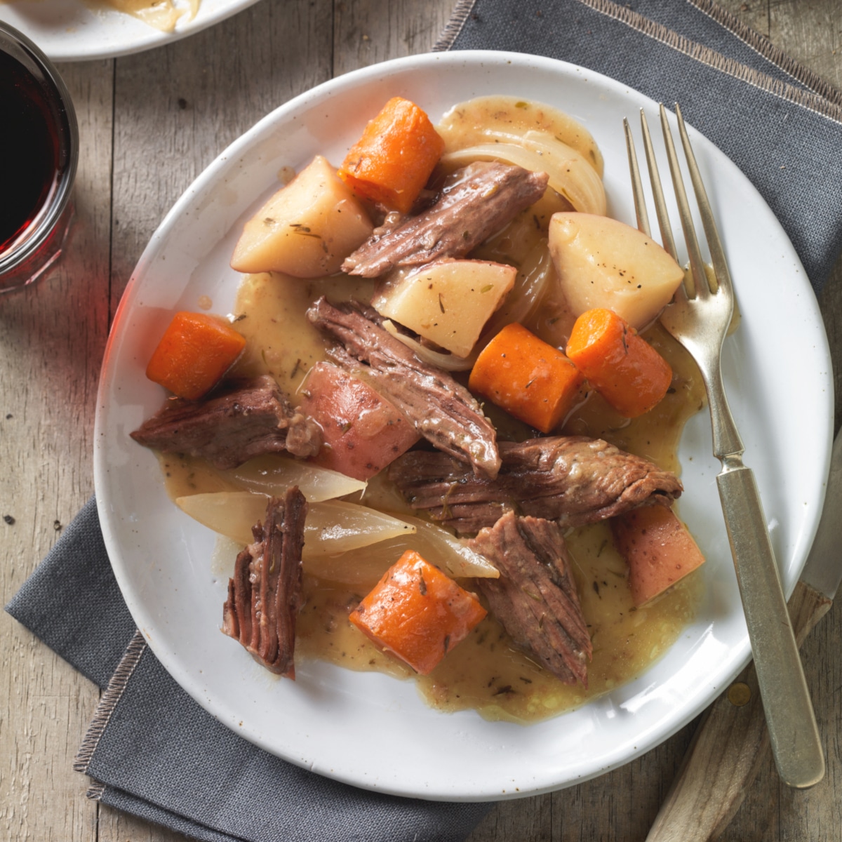Beef chuck roast cross rib roast served with potatoes and carrrots.