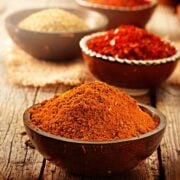 bowls of spices used for seasoning a beef eye of round roast - paprika, garlic granules, red pepper flakes