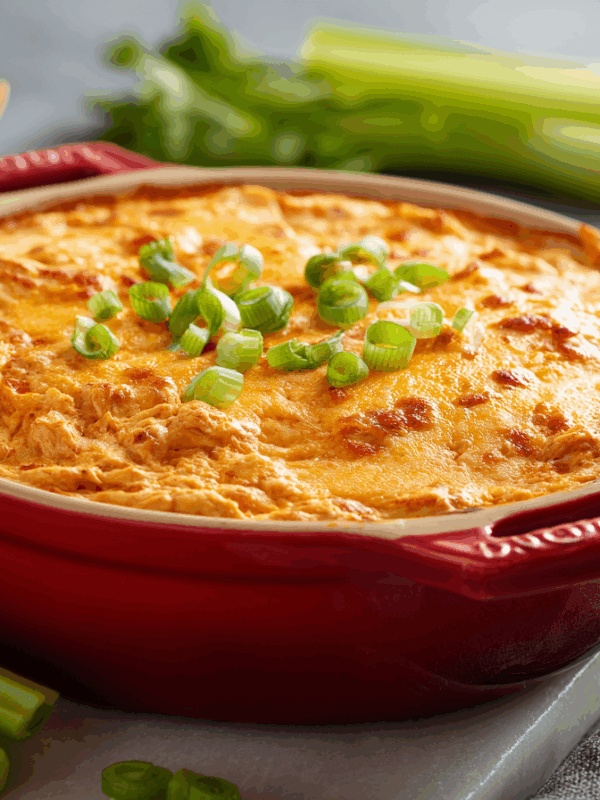 buffalo chicken dip in an oven baker with celery and chips on the side