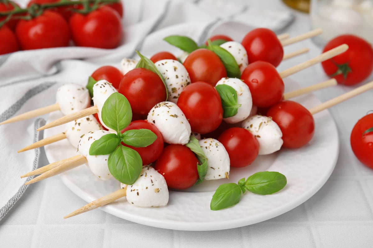 caprese skewers on a white plate.