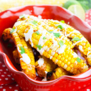 corn fries in a red dish drizzle with sour cream mixture and cilantro