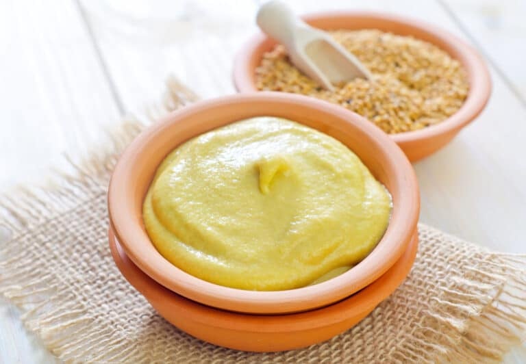 dijon mustard in a rustic bowl with mustard seeds