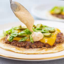 drizzling big mac sauce on burger taco