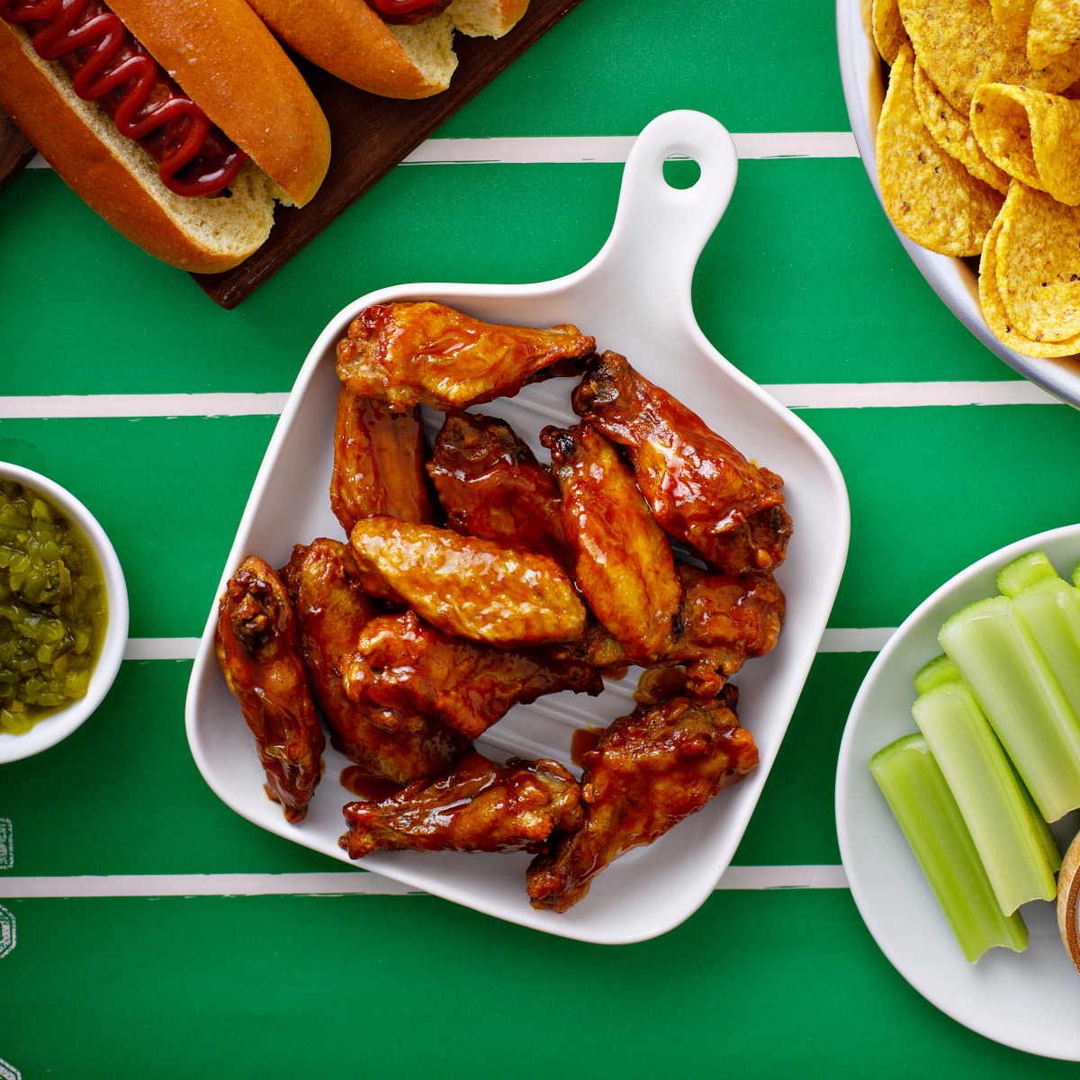 top down view appetizer wings served on a green football tablecloth for game day