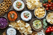 Crowd Favorite Party Dips That Never Fail assortment of party dips and spreads with chips, crackers and pretzels