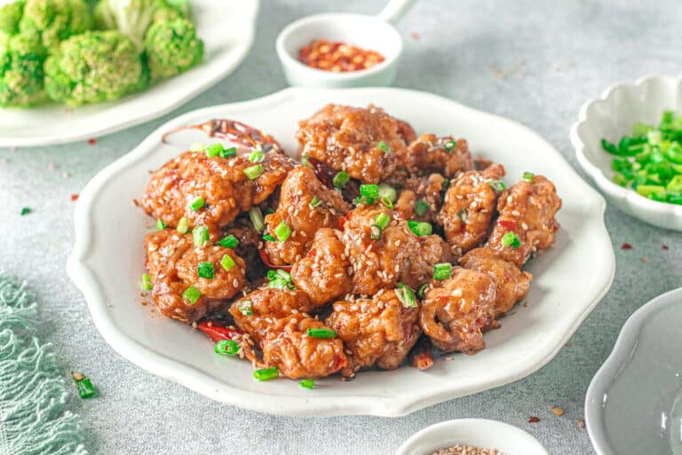 general tso's chicken served garnished with rice and broccoli side dishes