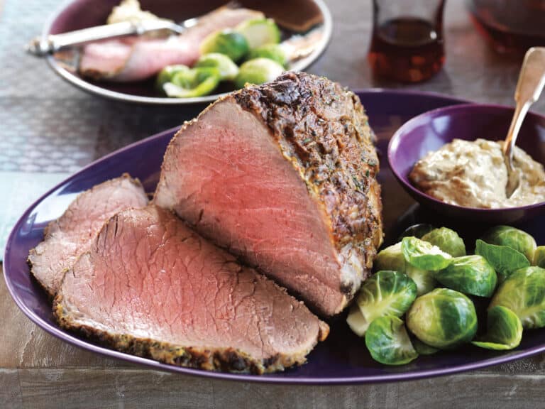 partially carved eye of round roast with brussels sprouts
