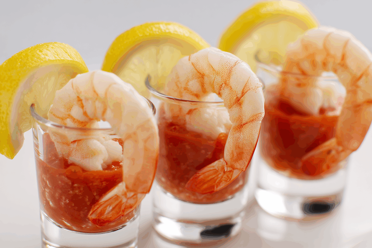 shrimp cocktail on cocktail sauce in shooter size glasses