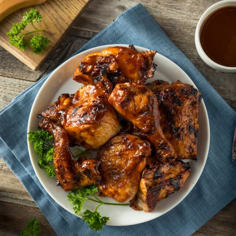 top down view of bbq chicken pieces on a white plate