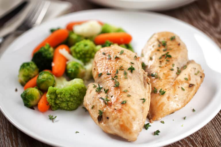 2 cooked Instant Pot frozen chicken breasts on a white plate