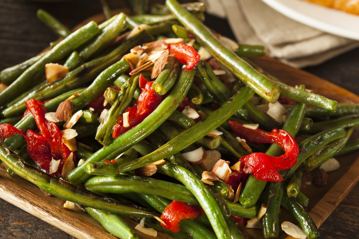 instant pot green beans with red pepper and nuts on a square plate