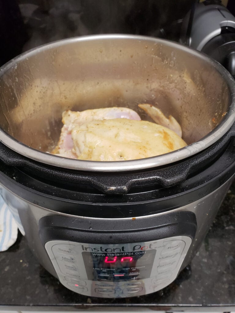 Whole chicken browning in the Instant Pot before pressure cooking for added flavor.