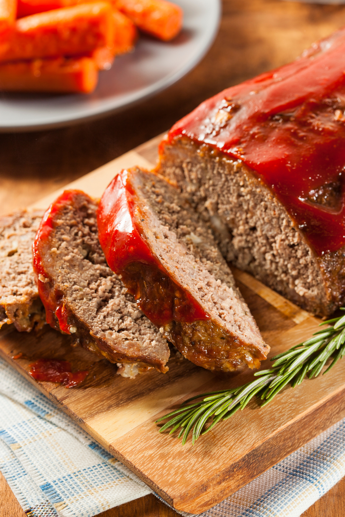 meatloaf recipe sliced with meatloaf glaze on a cutting board