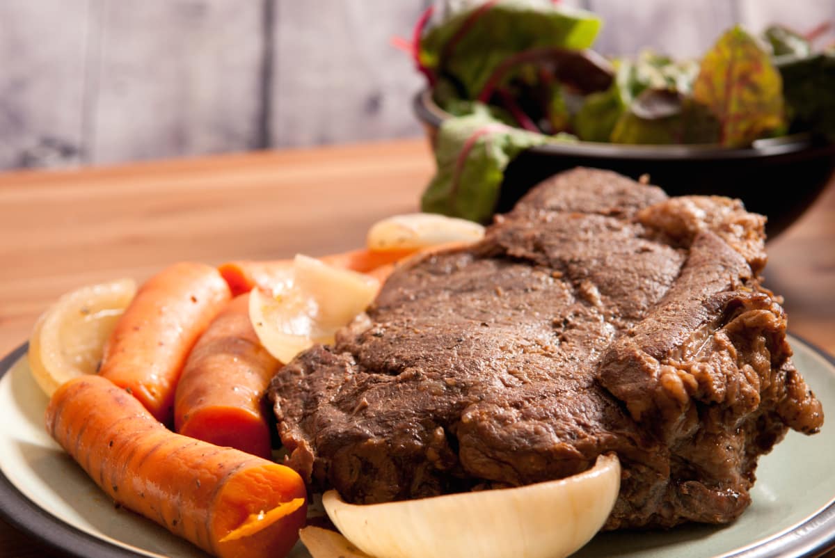 oven baked chuck roast recipe on a serving plate with carrots and onions