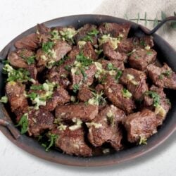 Closeup view of tender juicy seared beef sirloin steak tips garnished with parsley.
