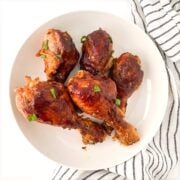 Slow cooker bbq chicken legs on a white plate.
