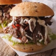 smoked chuck roast pulled and served on a bun. sandwich is drizzle with horseradish cream sauce.