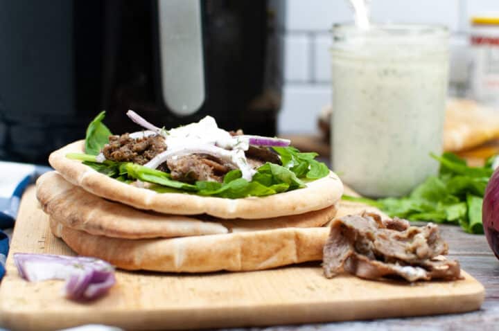air fryer gyros with tzatziki sauce in the air fryer in the background