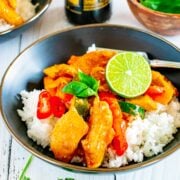 Square closeup view of Thai red curry chicken served on a bed of white rice